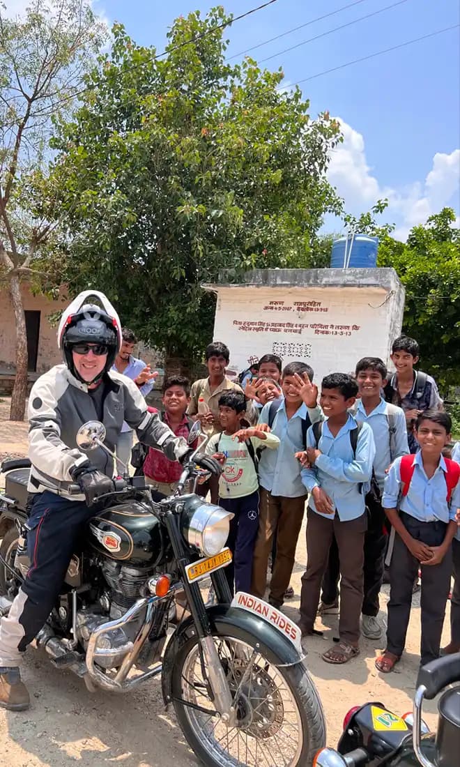 Indian Rides – Motorcycle Tour in Rajasthan Motorcyclist meeting schoolchildren during a Rajasthan motorcycle tour