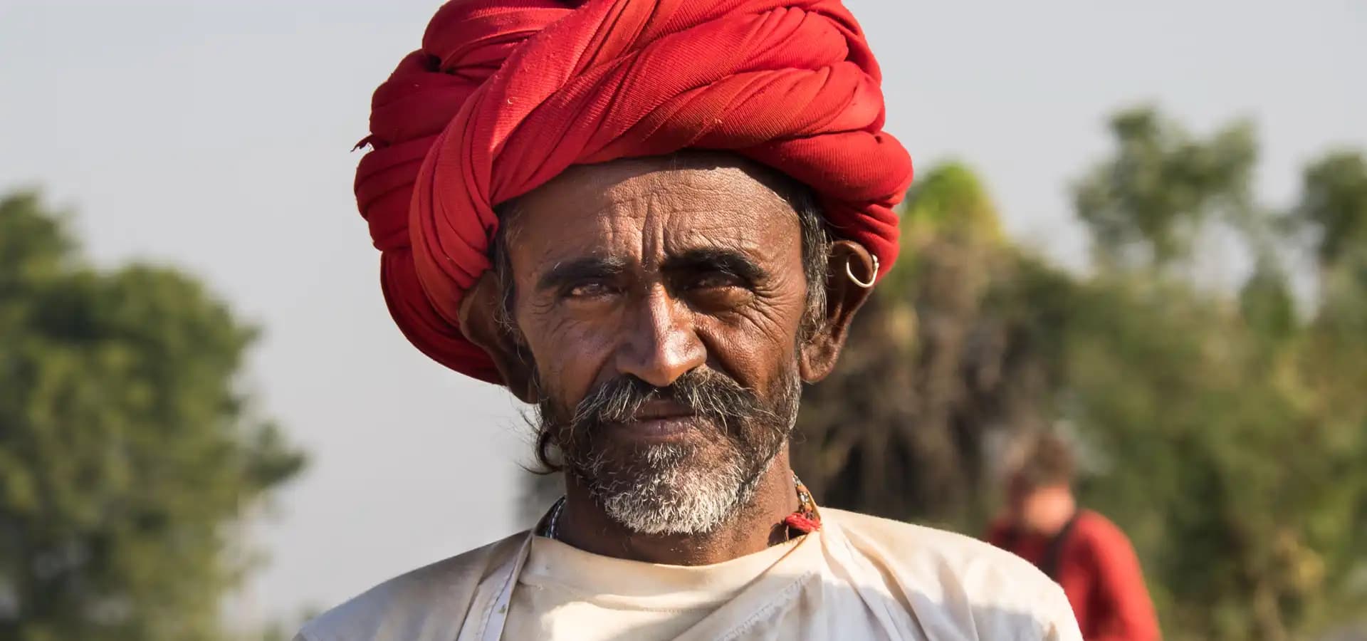 Indian Rides – Traditional Life and Culture in Gujarat Gujarati man wearing a traditional red turban during an Indian Rides motorcycle journey through rural Gujarat