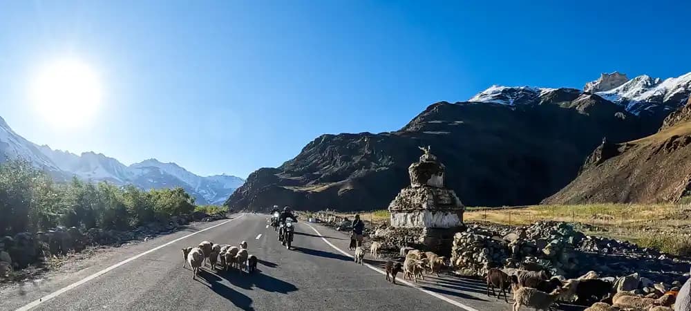 Moto sur une route de montagne au Ladakh avec les sommets enneigés de l’Himalaya en Inde Moto sur une route de montagne au Ladakh avec les sommets enneigés de l’Himalaya en Inde