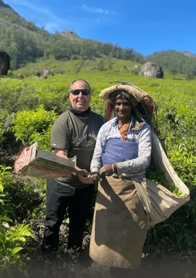 Munnar Tea Plantation – South India Motorcycle Tour Motorcycle traveler meeting a tea worker in a tea plantation in Munnar, South India